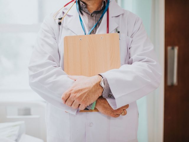 Physician holding a clipboard with medical information