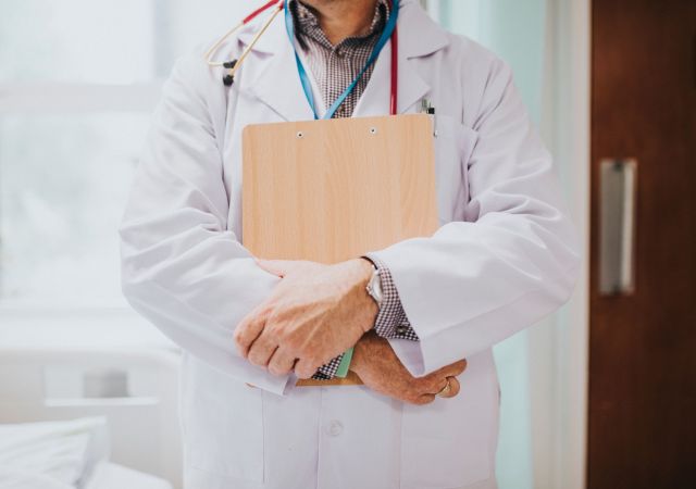 Physician holding a clipboard with medical information