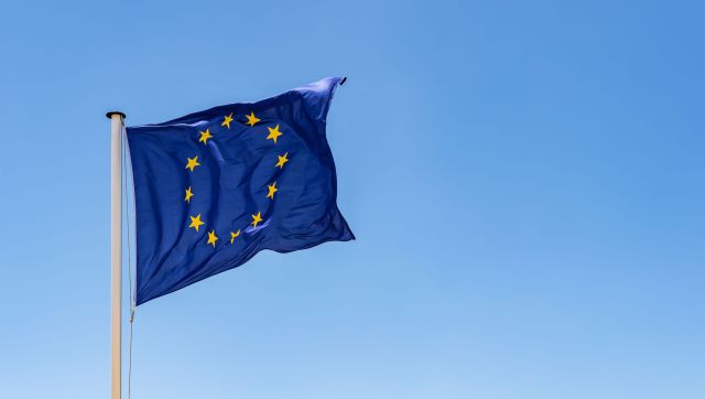 European Union Flag waving in the wind with a clear blue sky background